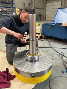 Engineer inspecting a machine component during assembly.