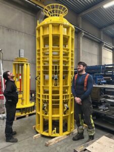 Technicians inspecting and adjusting machine components during assembly.